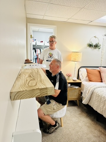 RRGA volunteer installing a custom shelf inside a bedroom during a transformation.
