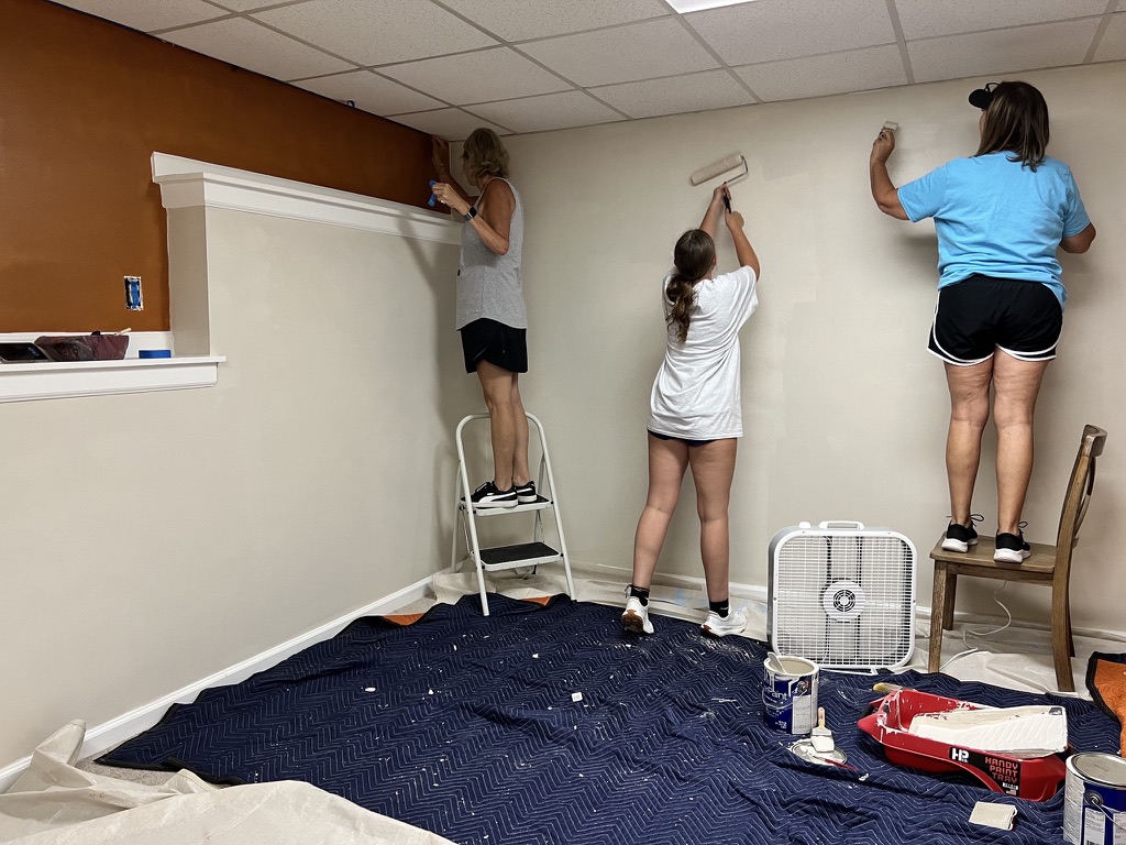 RRGA volunteers installing wall décor during a one-day bedroom transformation.