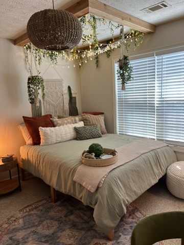 Completed neutral-toned RRGA bedroom with layered bedding, soft textiles and warm natural light.